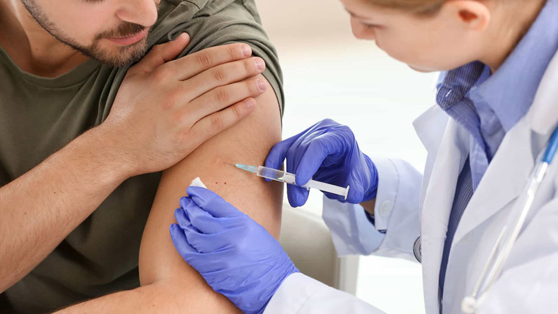 доктор делает прививку вакциной Pfizer